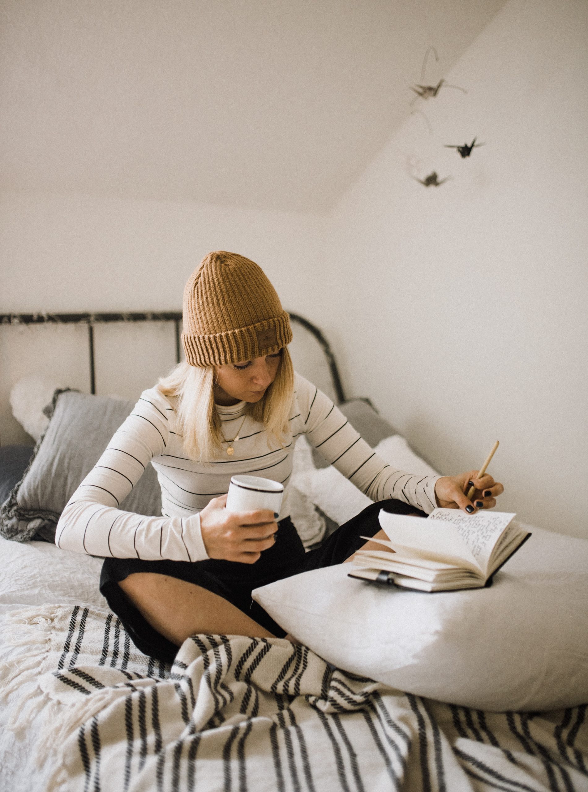 Writing in a notebook on a bed